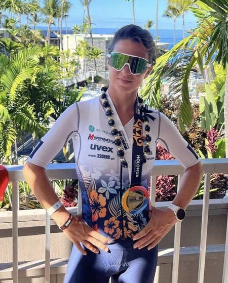 Triathlonistka w stroju I AM INSPIRATION z kwietnym wieńcem mety na Mistrzostwach Świata IRONMAN w Konie - plan treningowy triathlonowy IM Inspiration