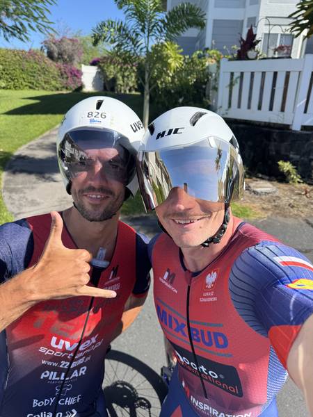 Dwóch triathlonistów w kaskach aero i strojach I AM INSPIRATION przed jazdą na czas - coaching triathlonowy IM Inspiration