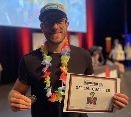 Uśmiechnięty triathlonista z certyfikatem Official Qualifier Mistrzostw Świata IRONMAN i medalem - coaching IRONMAN IM Inspiration