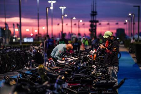 Triathloniści przygotowują rowery w strefie zmian o świcie przed startem IRONMANA - plan treningowy IRONMAN IM Inspiration