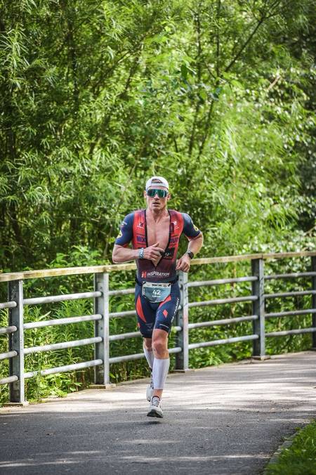 Triathlonista na biegowej części maratonu IRONMANA na bambusowej leśnej ścieżce - trening biegowy IRONMAN IM Inspiration